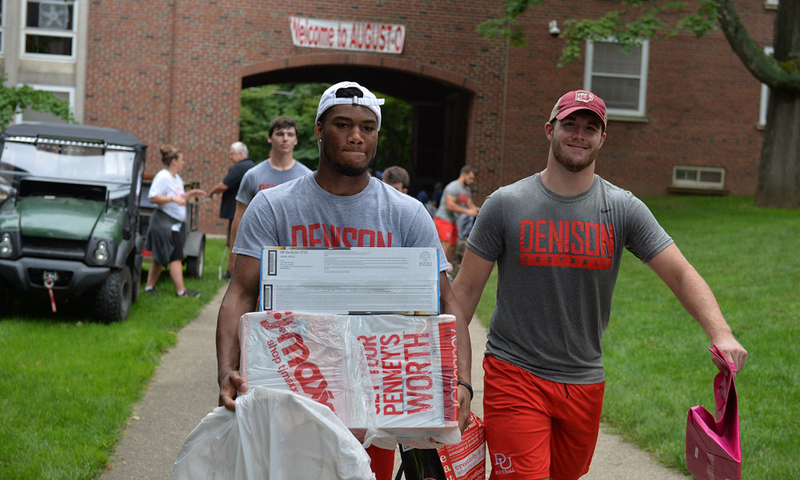 Football players helping people move in