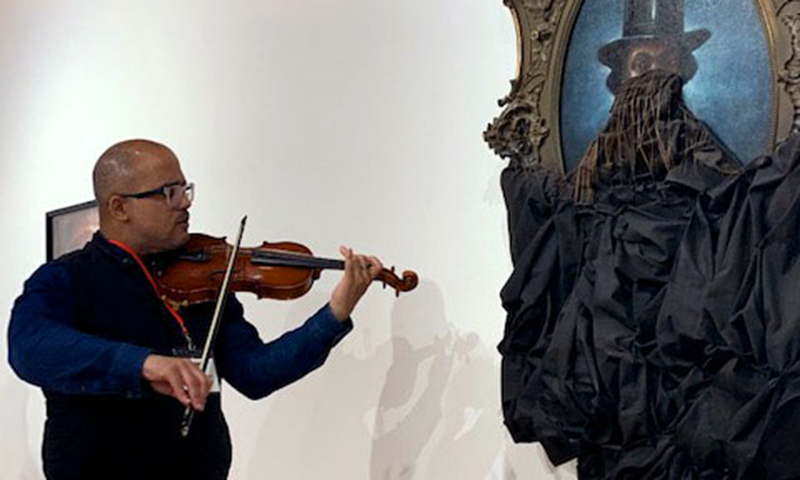 Daniel Roumain playing in concert with Titus Kaphar's A Disturbing Silence