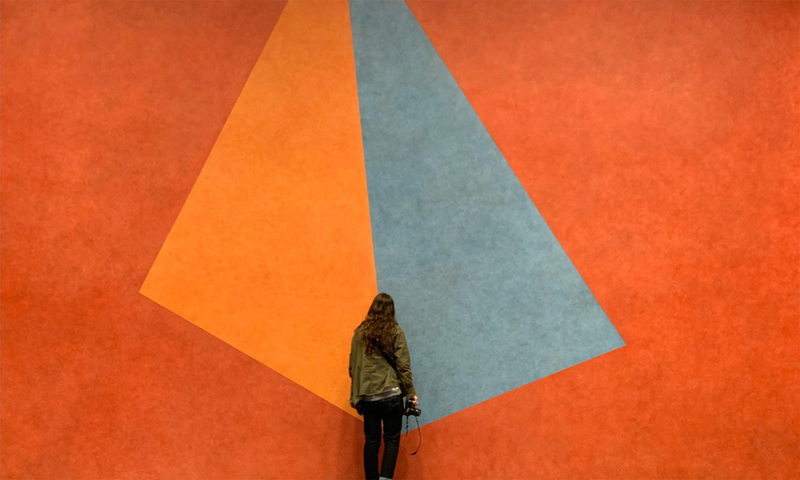 Student in front of an orange and grey wall