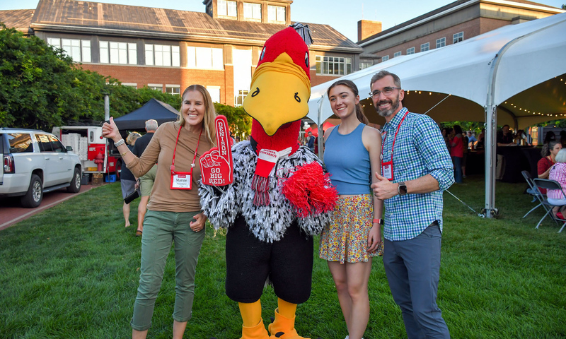A student and family pose with "Buzzy" during Family Weekend 2025.