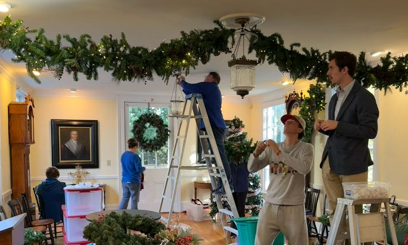 Denison students hanging stars on the swags in the long room