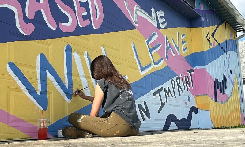 BFA student Mel Wienandt ’26 working on a mural.