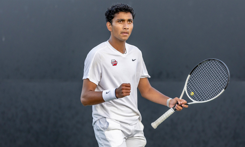 Photo of Kael Shah ’26 on the tennis court in his tennis uniform, holding a tennis racket.
