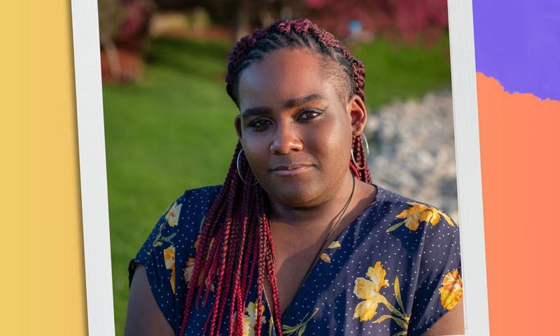 A person with long braided hair and a floral print dress stands outdoors in a garden setting, looking at the camera. The image is framed with the white edges of an instant-camera photo style border on a colorful background.