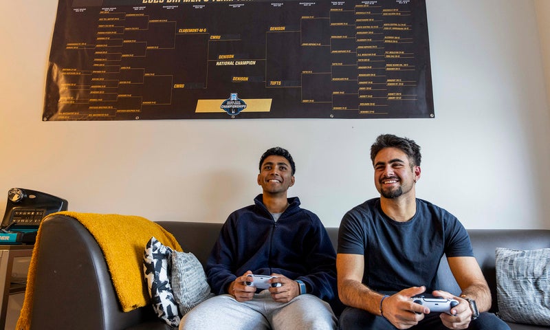 Kael Shah ’26 and Andreas Chapides ’26 sitting on a couch holding video game controllers.