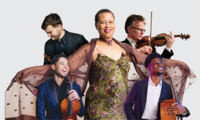 Five musicians pose together; one person stands in the center with a shawl spread out, while the others hold violin, viola, and accordion against a plain background.