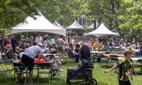 Photo of Denison alumni and families gathered on campus; several large white tents and tables full of people fill the quad.