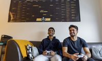 Kael Shah ’26 and Andreas Chapides ’26 sitting on a couch holding video game controllers.