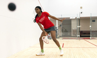 Da’Nerah Chisholm ’29 hits a ball on a squash court at Denison University.