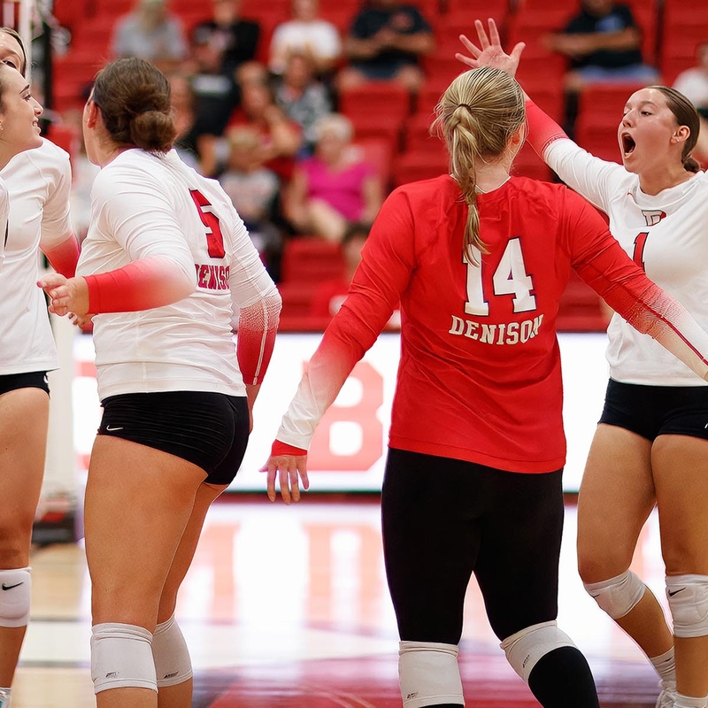 Denison's volleyball team celebrating a win.