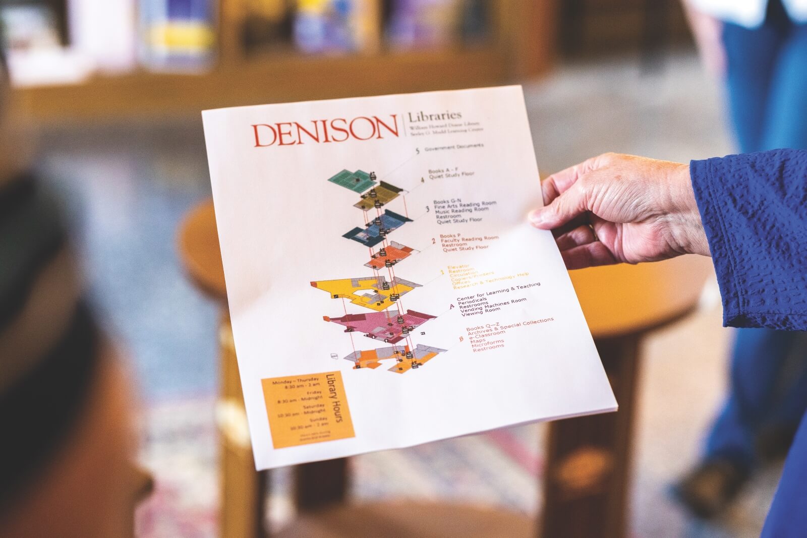 A person holding a paper of the library layout