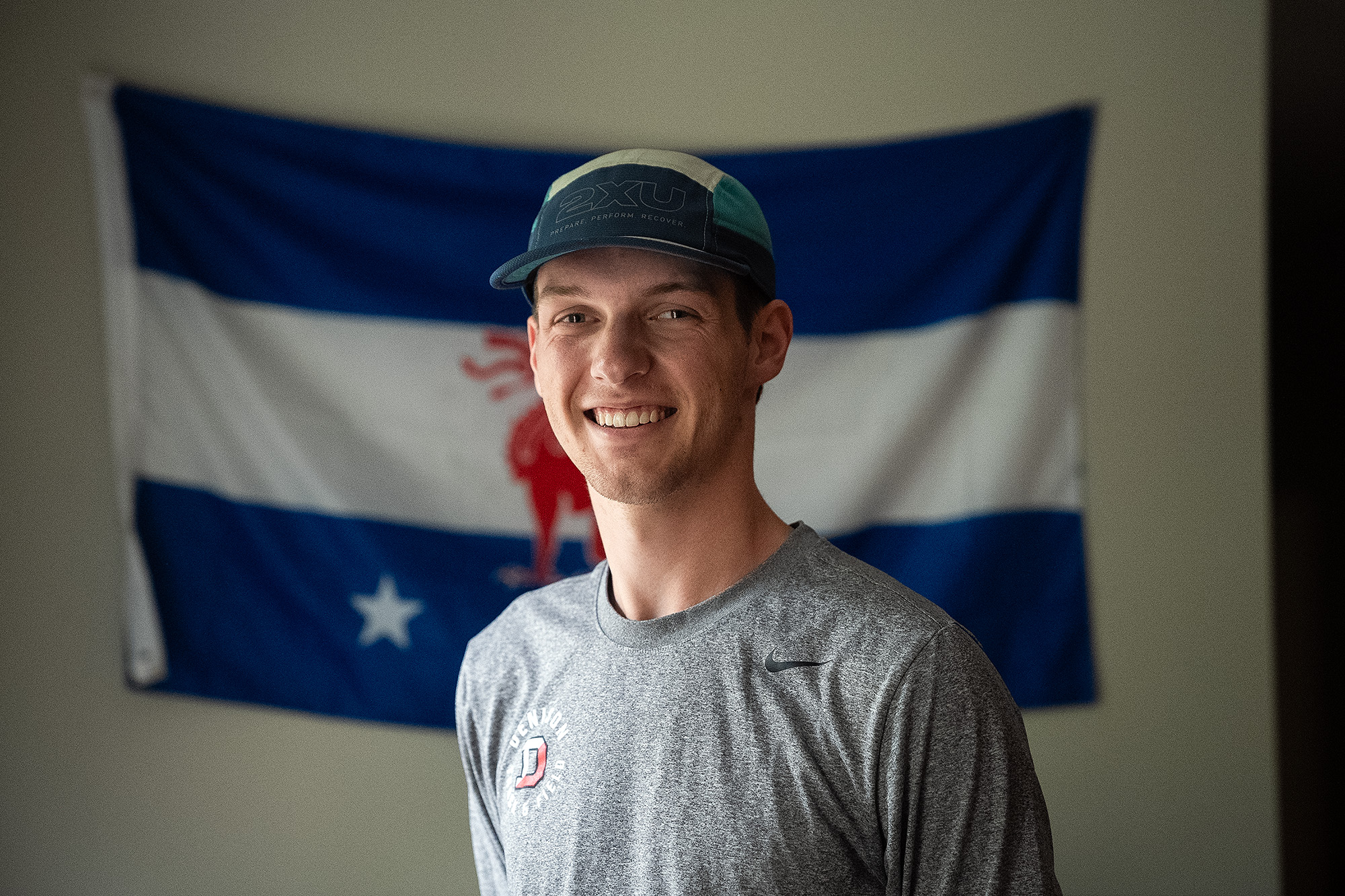 Worth Hinshaw stands in front of a flag representing his fraternity, Beta Theta Pi.. 