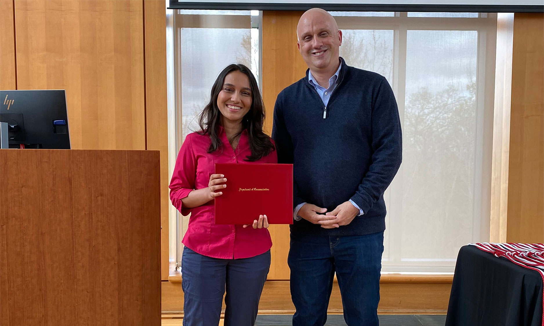 Student holding award with professor