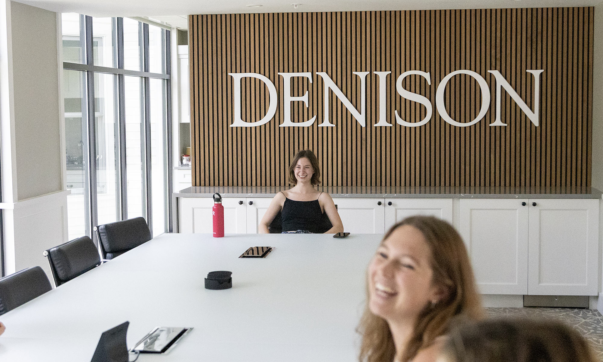 A student sits at the end of a conference table.