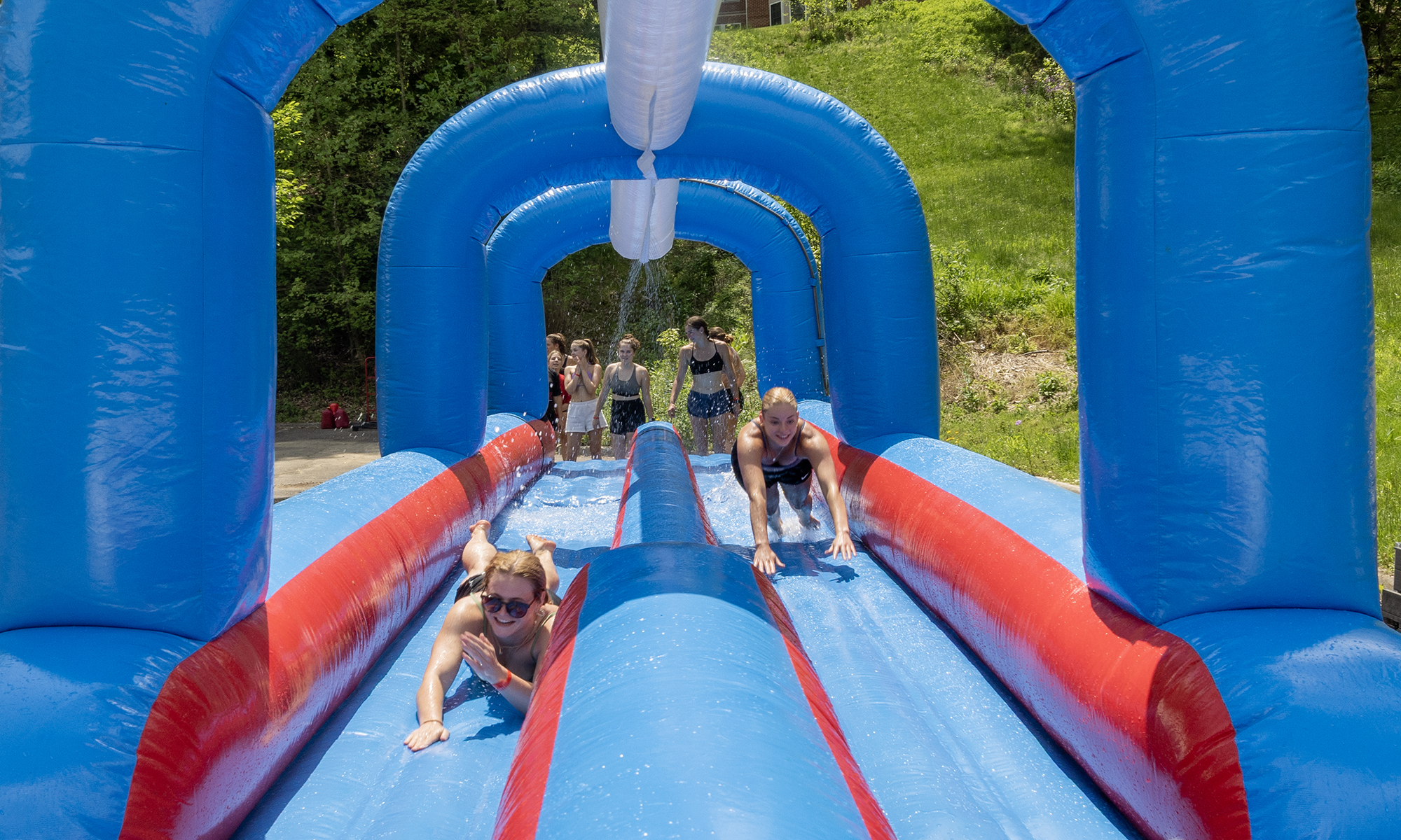 Students slides down a water slide.