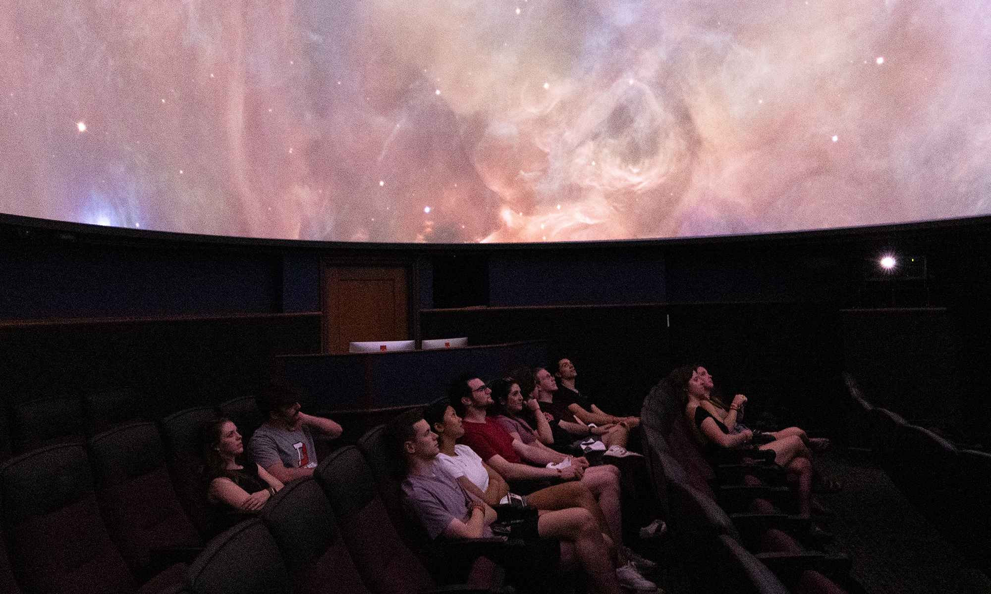Students observe a presentation inside the planetarium. 