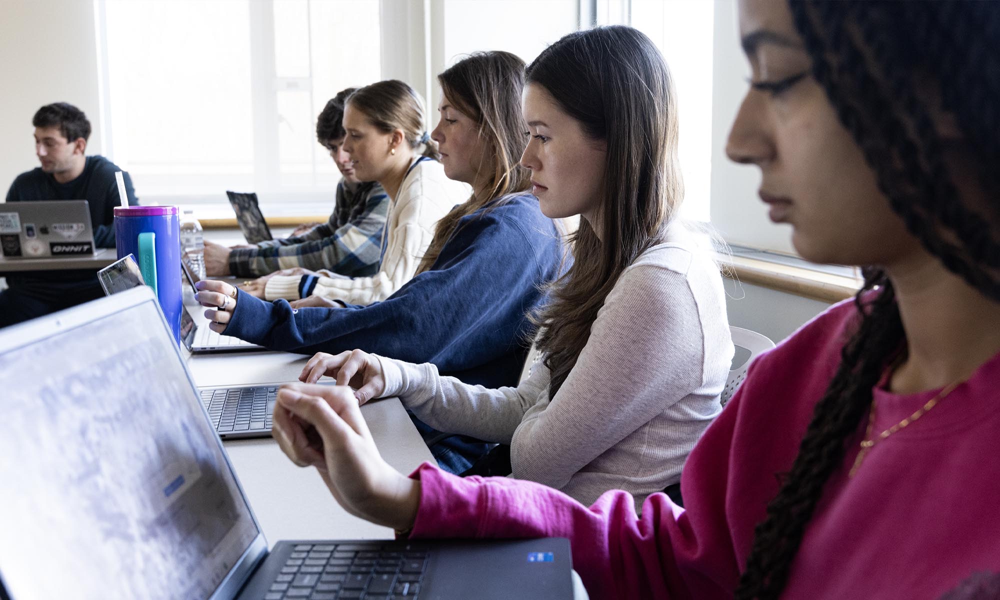 Several students with their computers in class.