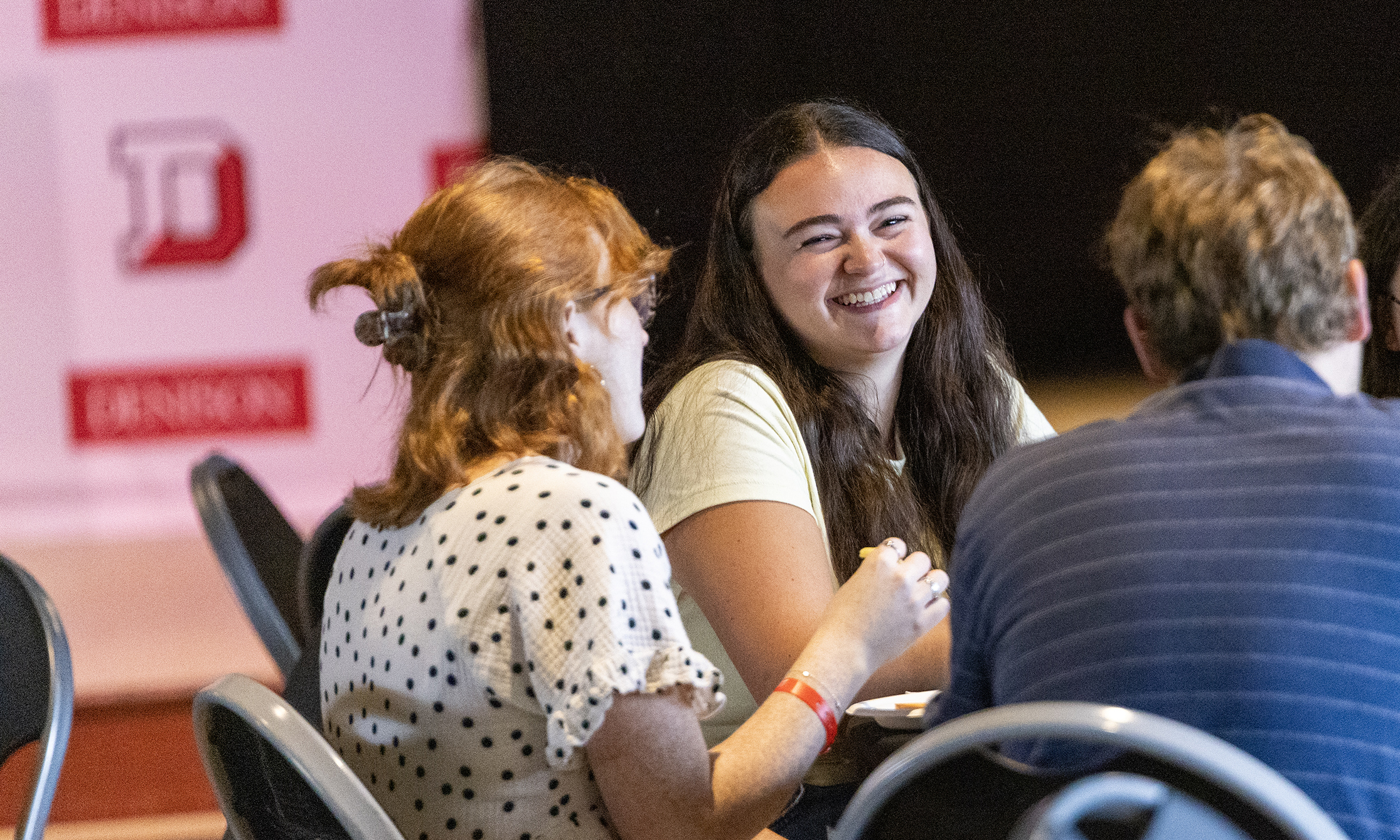Students smile at one another at the table.