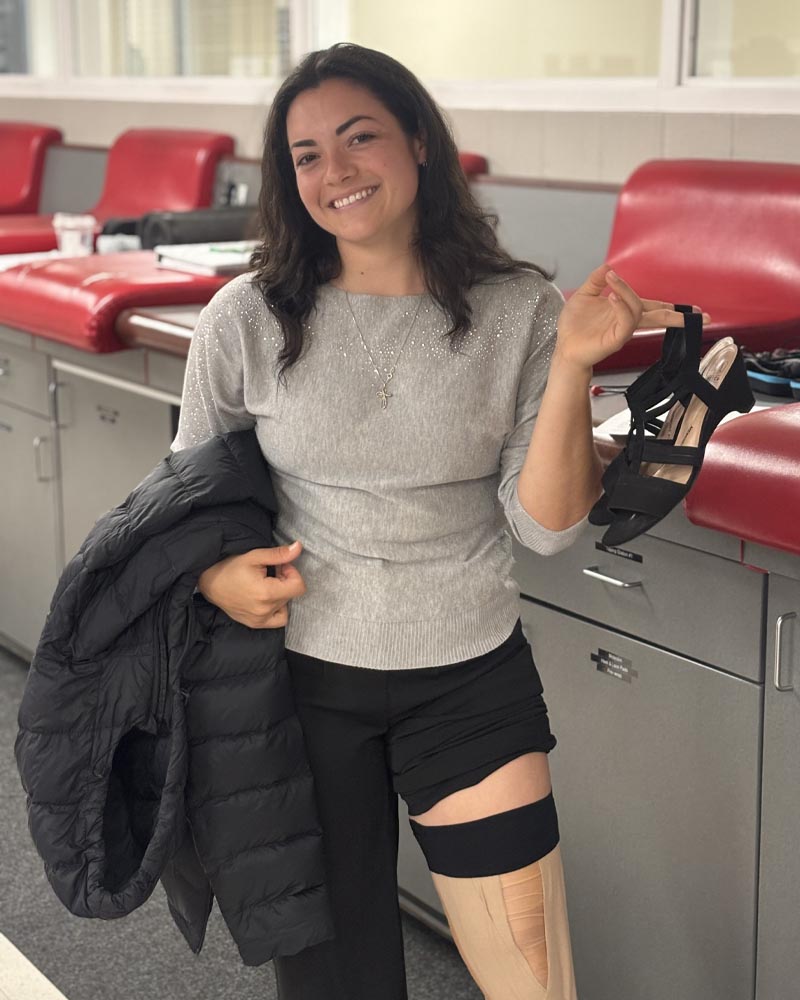 Annabelle Calderon in the trainers room with her legged wrapped and holding a pair of heels.