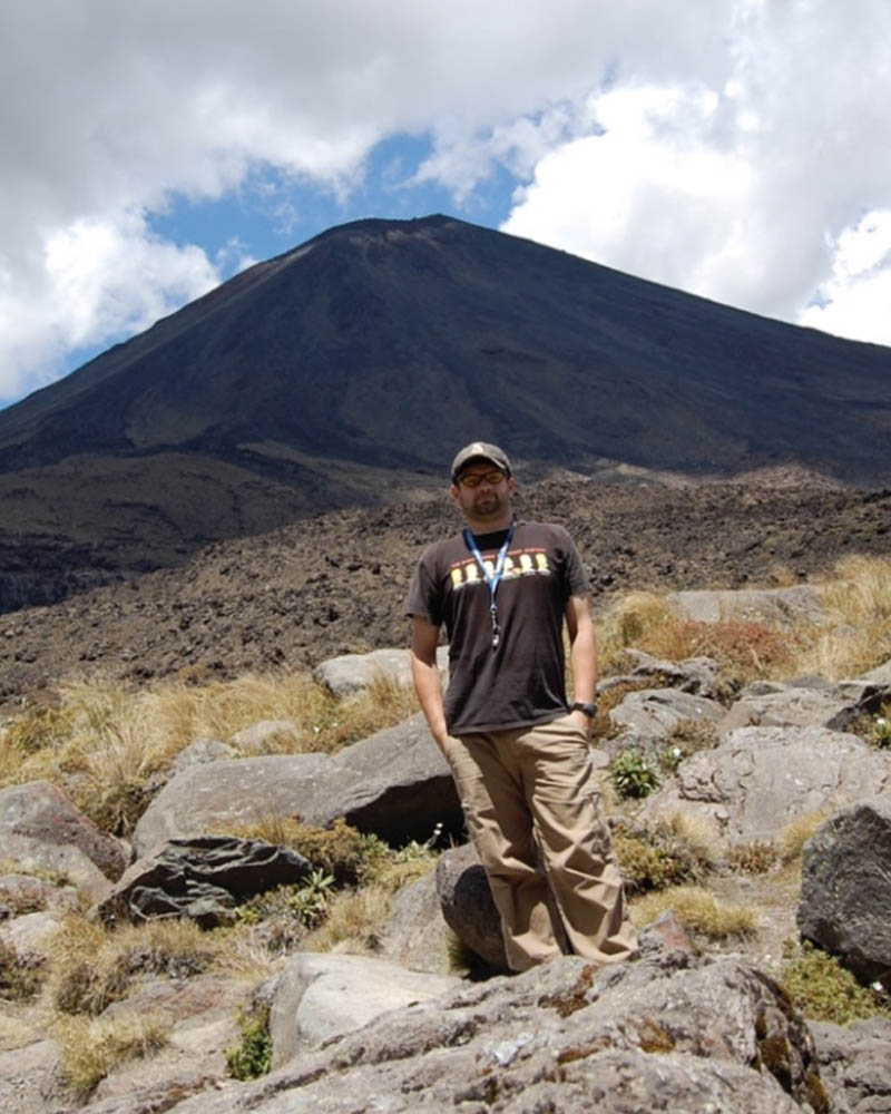 Erik Klemetti stands in front of a volcano.