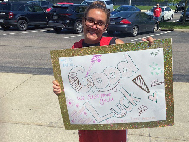 A student poses with a sign.