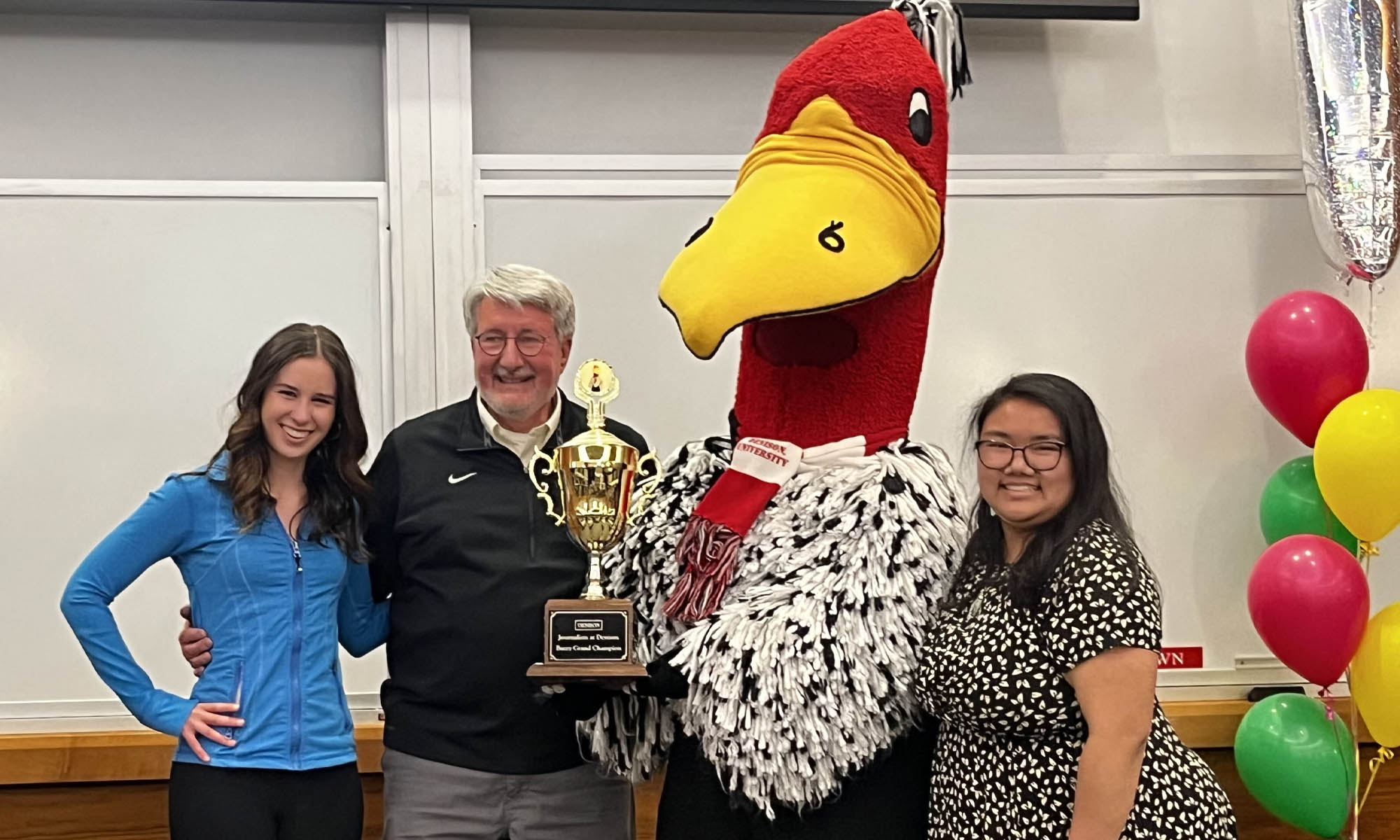 Maddie Luebkert ’27 and Shaye Phillips ’27 pose with Professor Alan Miller and Buzzy.
