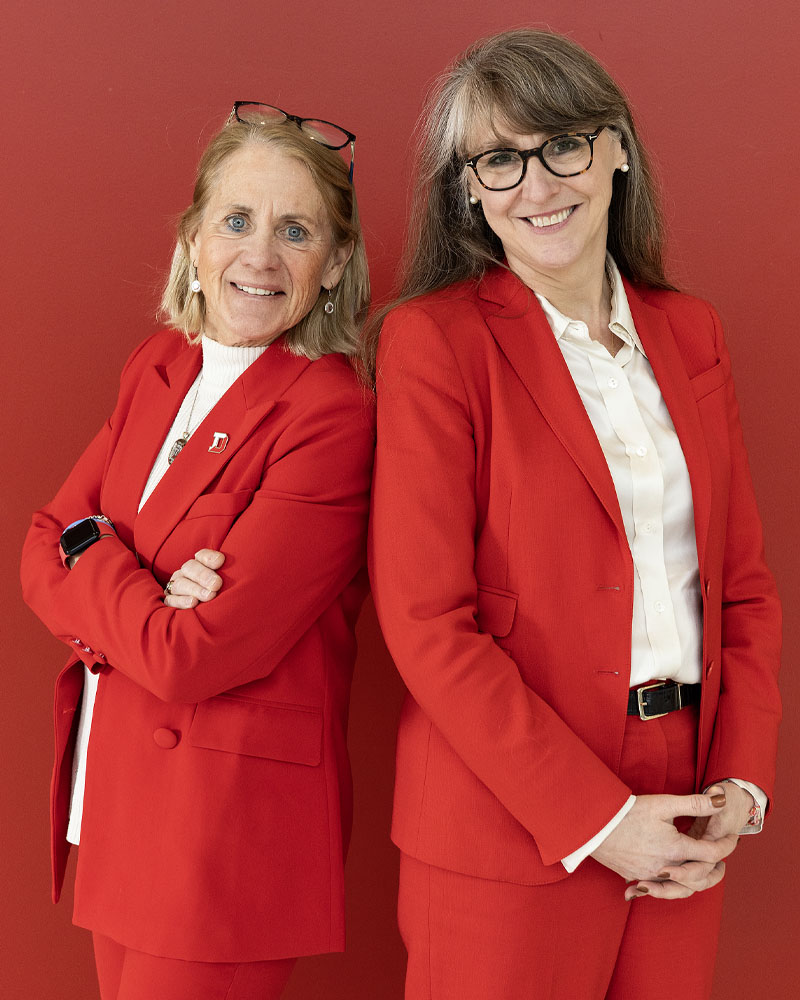 Nan Carney-Debord and Board of Trustees member Abigail Pringle '96, president of Wendy's national division, in matching red pant suits.